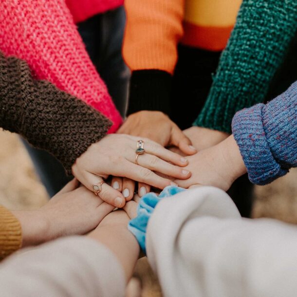 Diverse work colleagues putting their hands together.