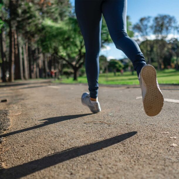 Woman running along park path.