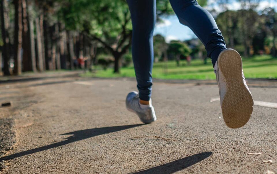 Woman running along park path.