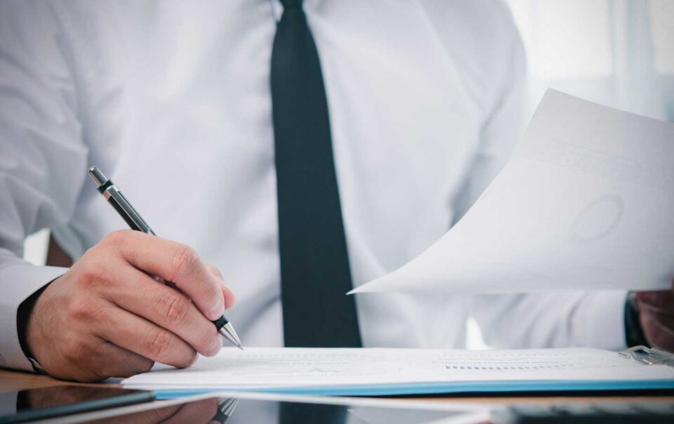 Accountant sitting at desk reviewing spreadsheets.