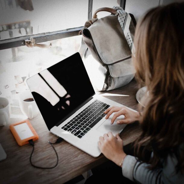 Business woman sitting at desk using laptop computer.