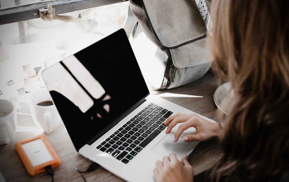 Business woman sitting at desk using laptop computer.