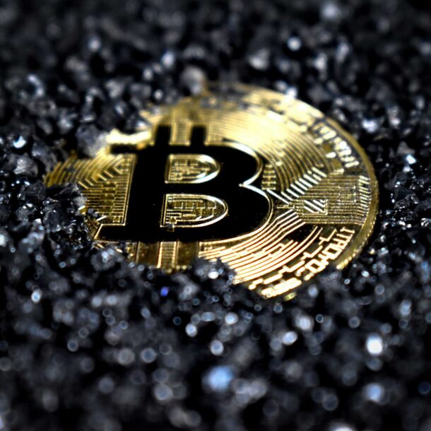 A Bitcoin covered in black crystals.