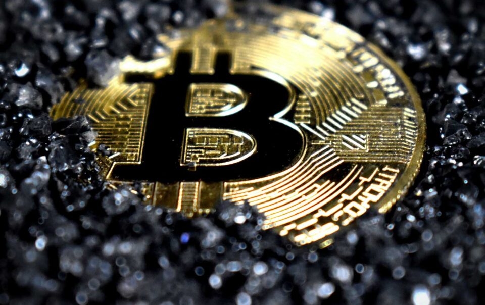 A Bitcoin covered in black crystals.