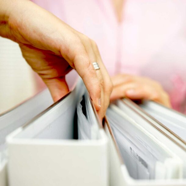 Person pulling out a binder of information.