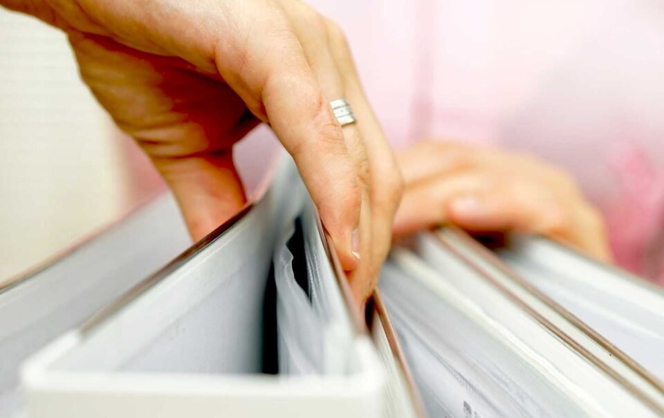Person pulling out a binder of information.