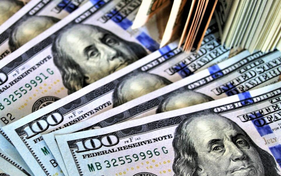A pile of $100 bills spread out.
