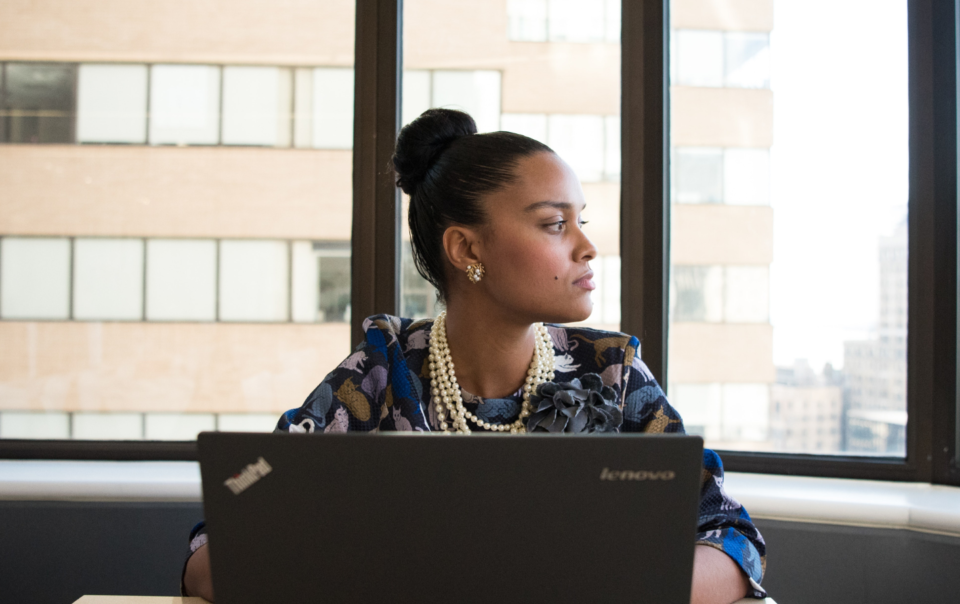 Woman Sits in Front of Black Laptop Computer