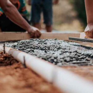 Workers smoothing out concrete for a sidewalk.