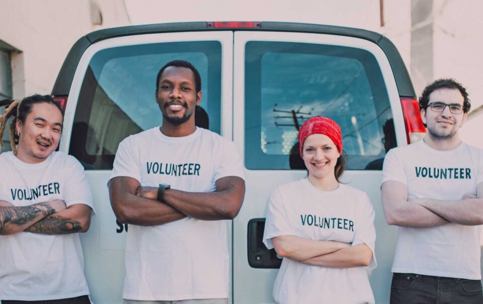 Local volunteers standing in front of a van.